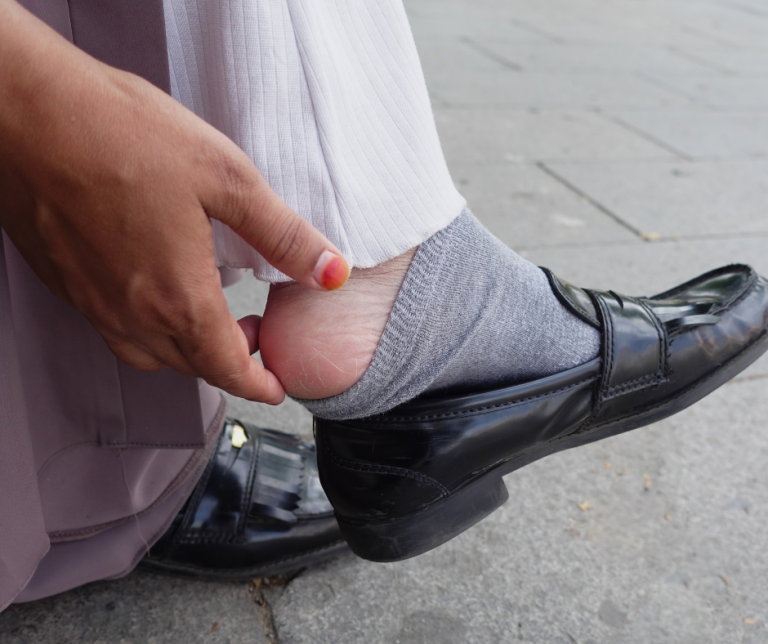 Home 28 woman removing shoe in pain